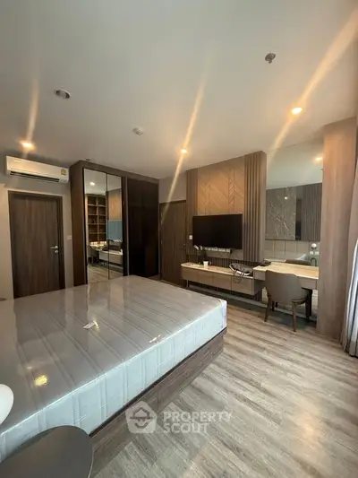 Modern bedroom with stylish decor, featuring a large bed, mirrored wardrobe, and elegant wooden finishes.