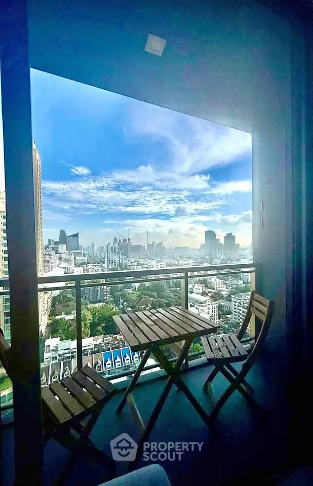 Stunning cityscape view from a modern balcony with outdoor seating, perfect for relaxation and enjoying the skyline.