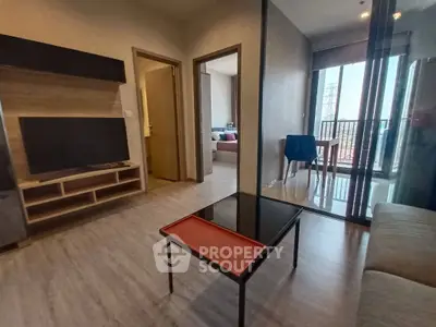 Modern living room with sleek furniture and balcony access in a stylish apartment.