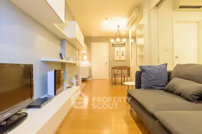 Modern living room with sleek design and cozy ambiance, featuring wooden flooring and stylish furniture.