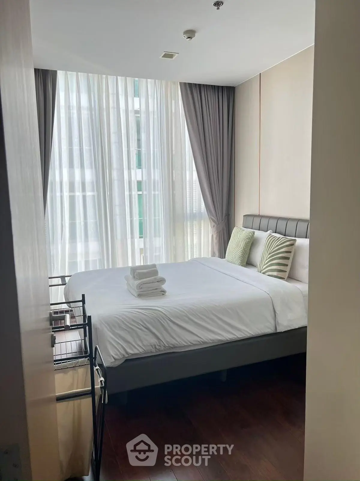 Cozy modern bedroom with large window and elegant curtains