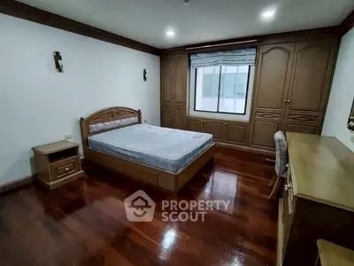 Spacious bedroom with wooden flooring and built-in wardrobe