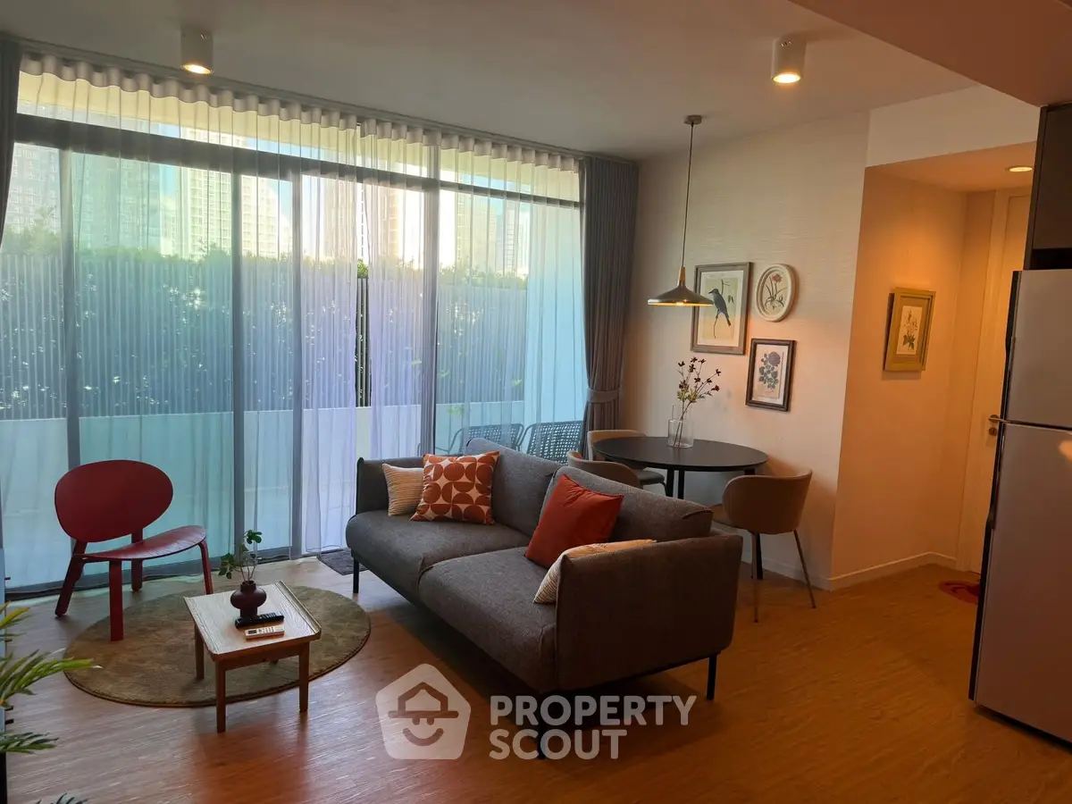 Modern living room with stylish decor and large windows offering natural light.