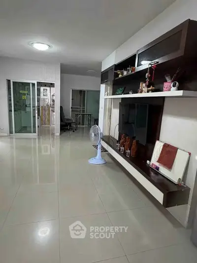 Spacious living room with modern shelving and glossy tiled floors