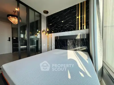 Luxurious modern bedroom with elegant black marble accent wall and stylish lighting fixtures.