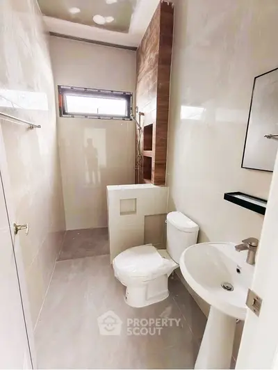 Modern bathroom with sleek fixtures and natural light from window.