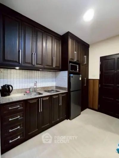 Modern kitchen with dark wood cabinets and sleek appliances