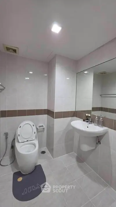 Modern bathroom with sleek fixtures and large mirror in a contemporary home.
