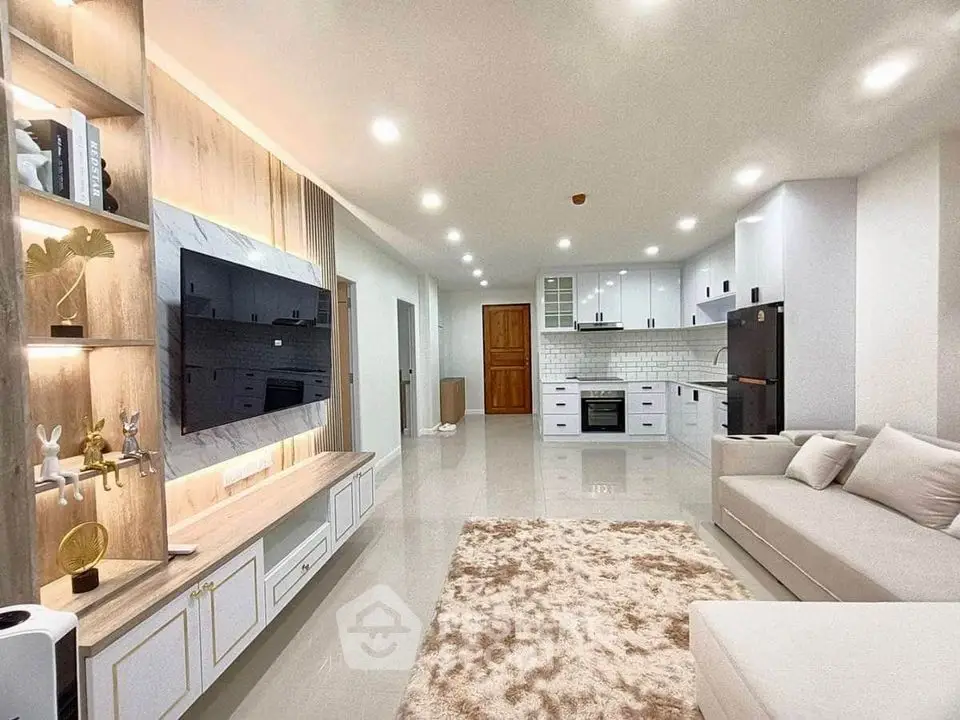 Spacious modern living room with open kitchen, sleek design, and cozy ambiance.
