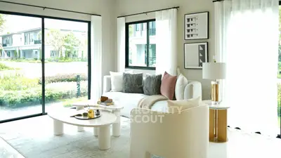 Bright and modern living room with large windows and stylish decor.