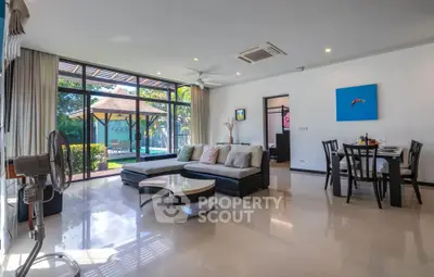 Spacious living room with pool view and modern decor in luxury home