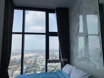 Luxurious bedroom with stunning city view through floor-to-ceiling windows, featuring elegant marble wall design.