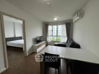 Modern living room with sleek furniture and large window offering natural light in a contemporary apartment.