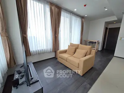Spacious living room with large windows and modern furnishings in a contemporary apartment.