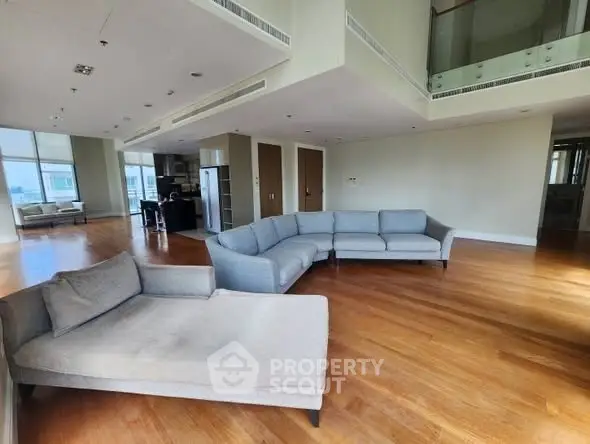 Spacious modern living room with elegant furniture and wooden flooring in luxury apartment.