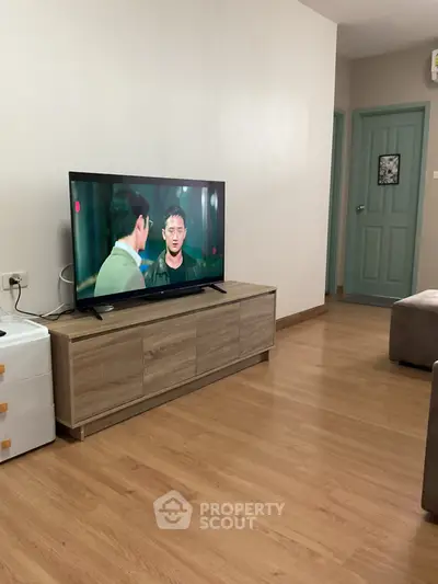 Modern living room with wooden flooring and sleek TV stand, showcasing a cozy and inviting atmosphere.