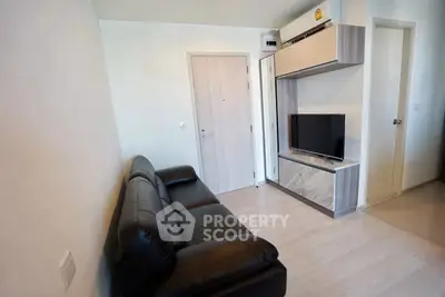 Modern living room with sleek black sofa and wall-mounted TV unit