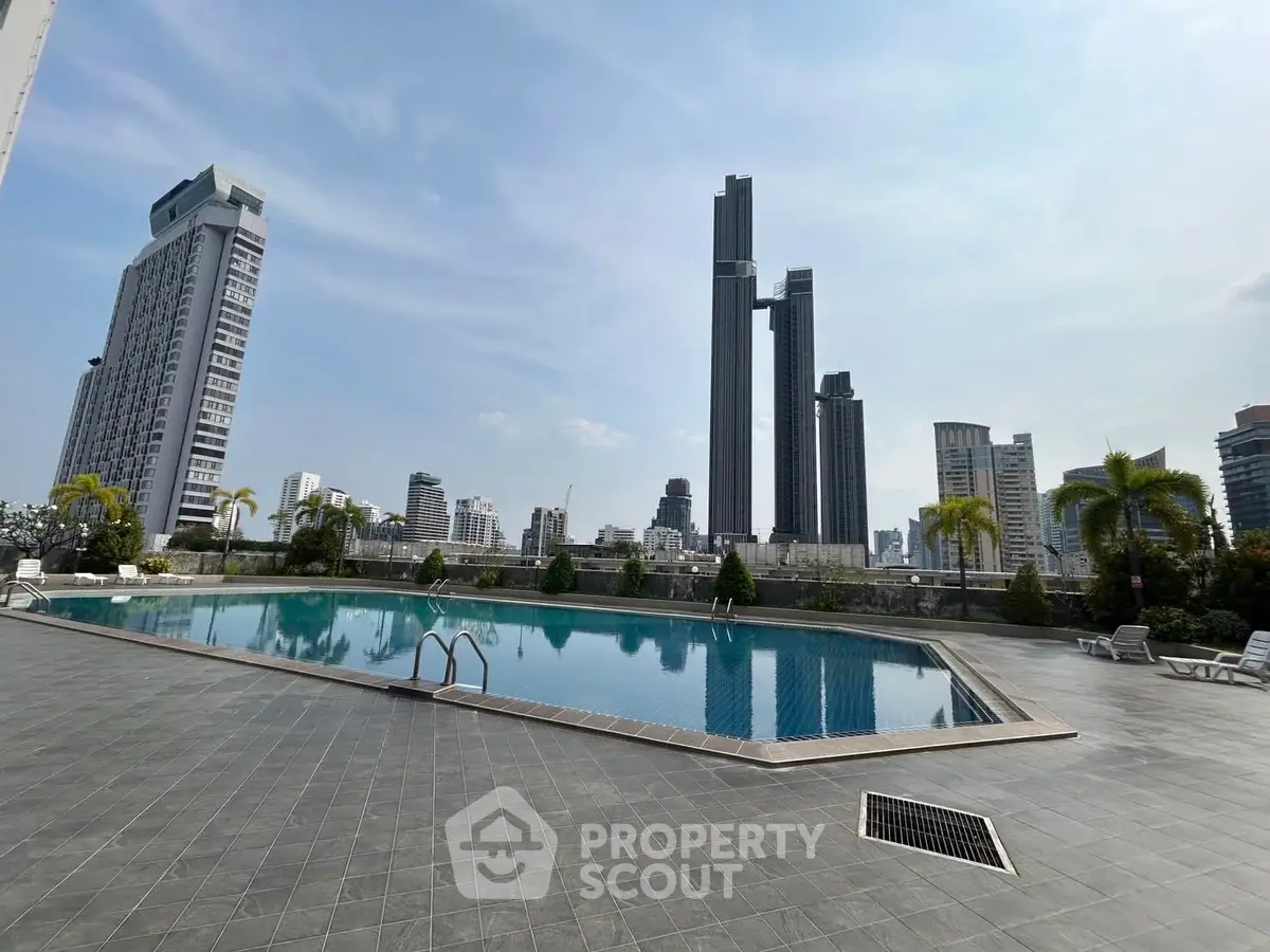 Luxurious rooftop pool with stunning city skyline views in a modern high-rise building.