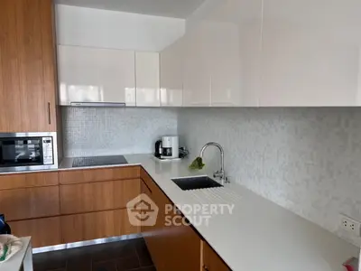 Modern kitchen with sleek cabinetry and integrated appliances in a stylish apartment.