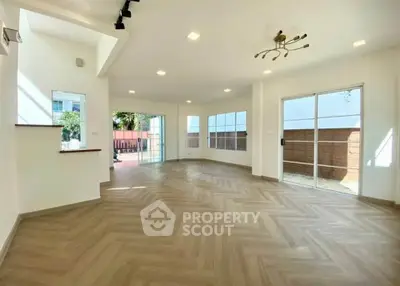 Spacious modern living room with large windows and elegant flooring, perfect for natural light lovers.