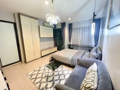 Modern bedroom with stylish decor, cozy seating area, and ample natural light.