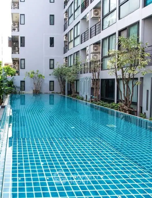 Luxurious apartment building with a stunning outdoor pool and modern design.