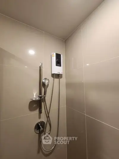 Modern bathroom shower area with sleek tiles and water heater