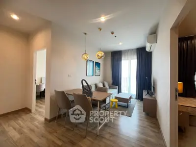 Modern living room with dining area, stylish lighting, and cozy decor in a contemporary apartment.