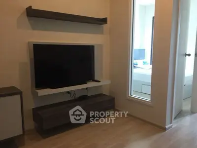 Modern living room with wall-mounted TV and sleek wooden shelves.