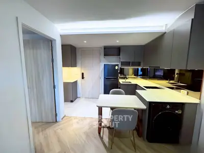 Modern kitchen with sleek cabinetry, integrated appliances, and cozy dining area in stylish apartment.