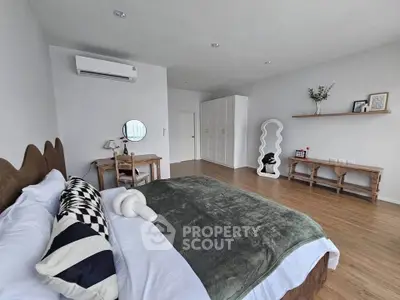 Spacious modern bedroom with stylish decor and wooden flooring