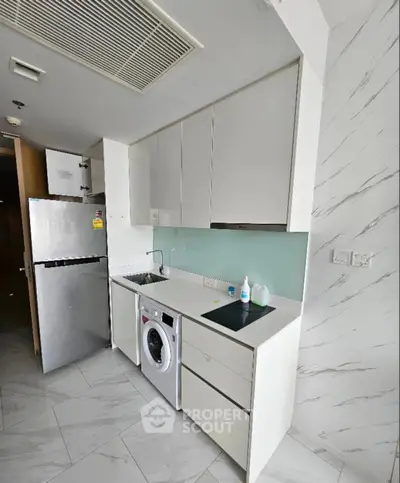 Modern compact kitchen with washing machine and sleek cabinetry