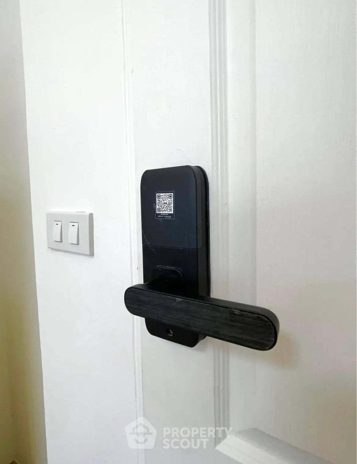 Modern smart lock on white door with sleek design and QR code access.