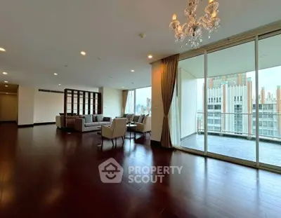 Spacious modern living room with elegant chandelier and large balcony view