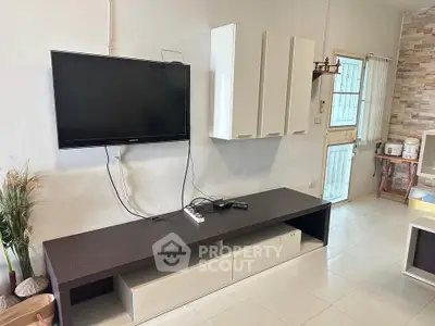 Modern living room with wall-mounted TV and sleek storage units