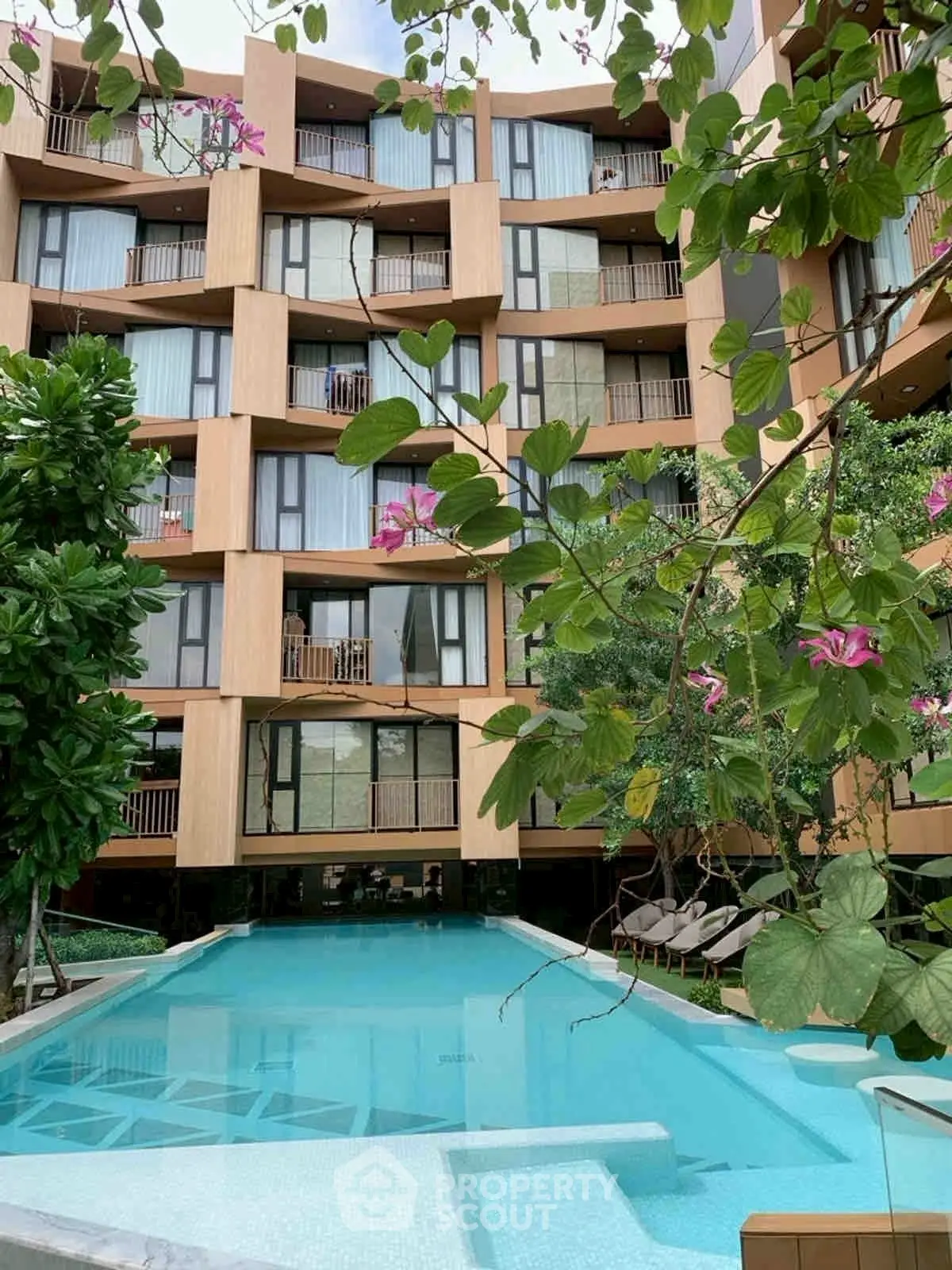 Luxurious modern apartment complex with stunning pool and lush greenery