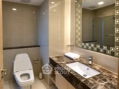 Luxurious modern bathroom with elegant marble countertop and stylish mirror design.