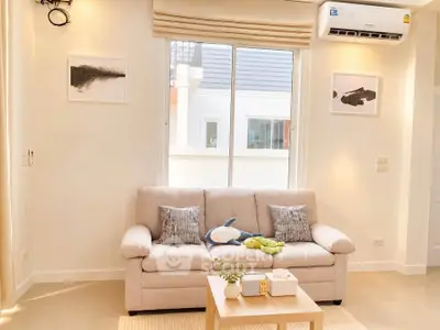 Bright and cozy living room with plush sofa and modern decor, perfect for relaxation.