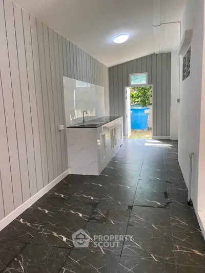 Modern kitchen with sleek black marble flooring and stylish panel walls