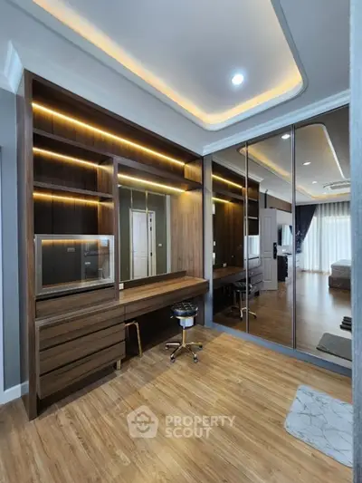 Modern bedroom with wooden flooring and mirrored wardrobe