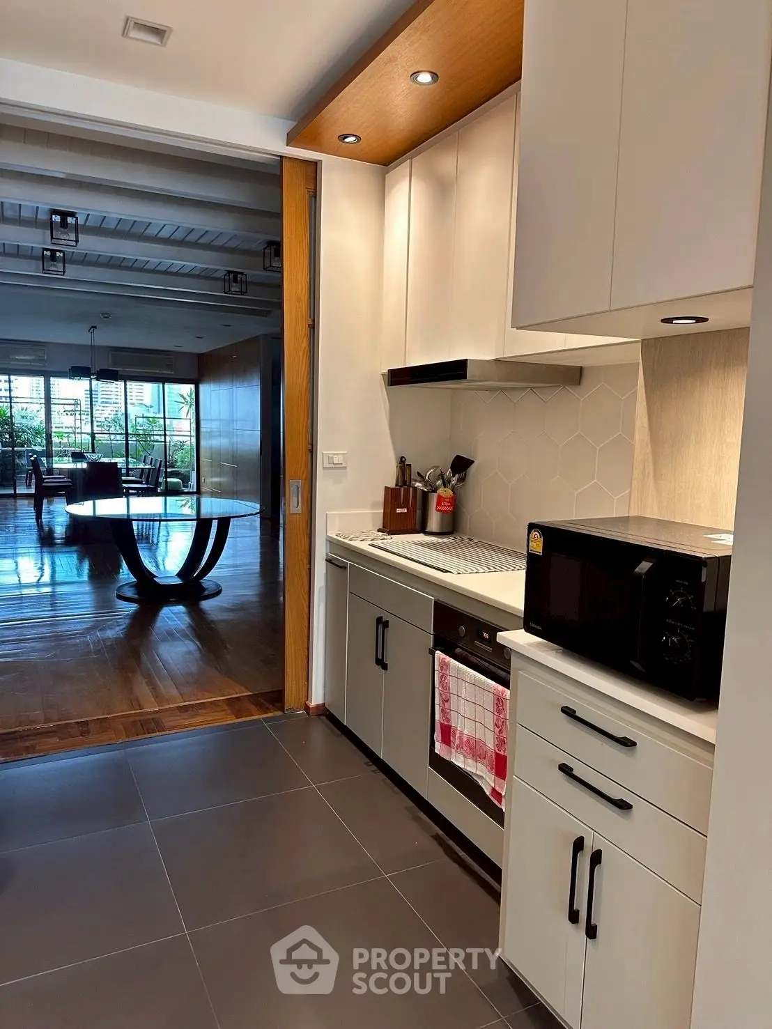 Modern kitchen with sleek cabinetry and open layout leading to spacious living area.