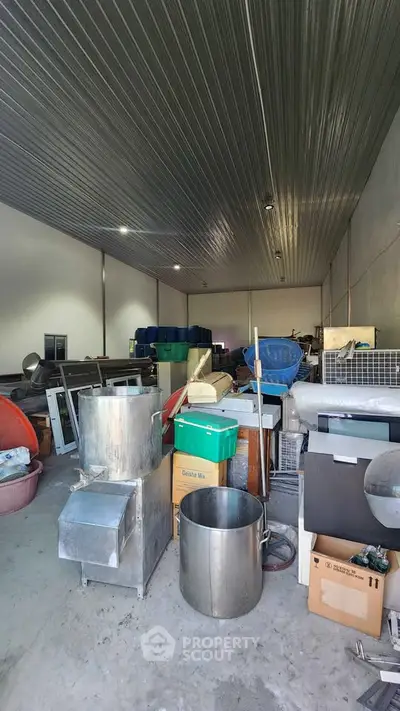 Spacious storage unit with metal containers and assorted equipment, ideal for industrial use.
