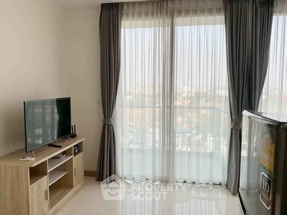 Bright living room with large windows and modern TV setup