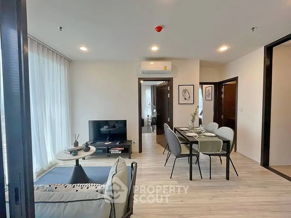 Modern living room with dining area, stylish decor, and natural light in a contemporary apartment.