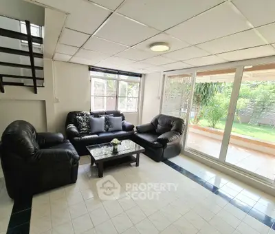 Spacious living room with garden view and modern leather furniture