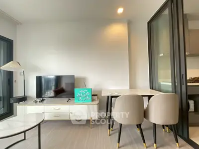 Modern living room with sleek furniture and TV, featuring a stylish dining area.