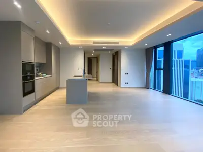 Luxurious open-plan kitchen and living area with city view in modern apartment.