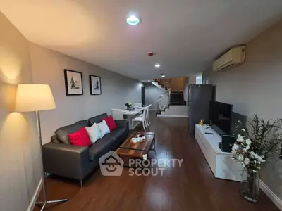 Modern living room with stylish decor, cozy seating, and elegant dining area in open layout apartment.