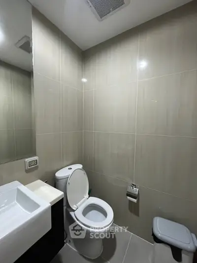 Modern bathroom with sleek fixtures and neutral tiles, perfect for a contemporary home.