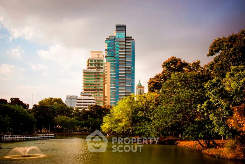 Stunning high-rise building with lush greenery and serene water view in urban setting.